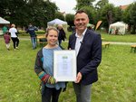 Foto: Maria Havemann von der Steuerungsgruppe Fairtrade übergibt die Urkunde an Bürgermeister Sascha Zimmermann (JPG-Datei)